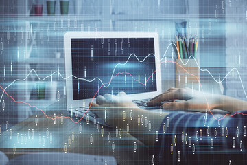 Double exposure of woman hands typing on computer and forex chart hologram drawing. Stock market invest concept.