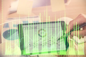 Double exposure of man's hands holding and using a phone and financial chart drawing. Market analysis concept.