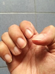 Gesture of an Asian men's hand holding something showing its brown skin or tanned skin and its fingernails