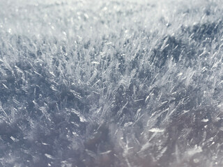 Crystal snow background. Macro ice sparkle backdrop. Winter icy snowy surface. Fluffy Christmas snow closeup.
