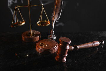 Divorce and law concept. Judge gavel and gold rings on a glossy table