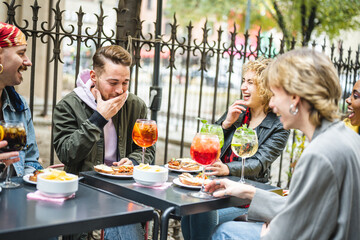 Lgbt group of diverse people sitting at restaurant having fun, happy friends laughing and joking,...