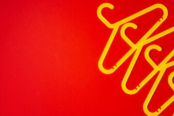 Hanger on red paper background. Minimalistic fashion concept. Top view