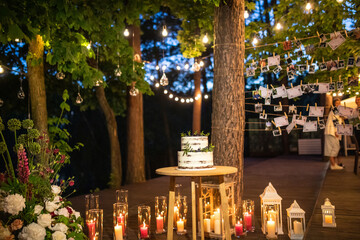 night wedding ceremony, the arch is decorated with flowers, candles and garlands of light bulbs and...