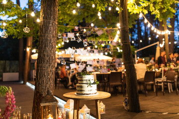 night wedding ceremony, the arch is decorated with flowers, candles and garlands of light bulbs and...