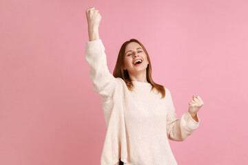 Portrait of blond woman showing yes gesture and screaming celebrating her victory, success, dreams...