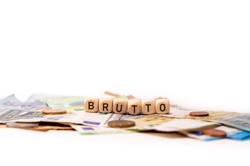 Obraz na płótnie Canvas German word for gross, BRUTTO, spelled with wooden letters wooden cube on a plain white background with banknotes and coins, concept image
