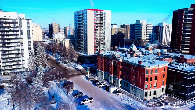 Edmonton Canada 116 Street NW intersection of 100 Ave NW and Victoria Park Road aerial winter sunny flying towards the busiest downtown West side intersection next to Grant Noltey Park snow covered
