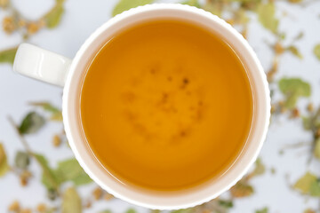 Winter Herbal tea on a white background. Linden tea. immune-boosting herbal tea. Medicinal tea prepared from linden leaves, Clove particles and Chamomile. Top view. Selective focus