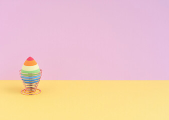 cosmetic sponge in the form of an egg on a mellifluous stand on a yellow-pink background. Copy space.