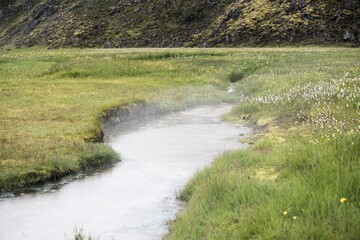 Fototapeta premium Wasserdampf über einem Bach mit warmen Wasser am beliebten WandergebietLandmannalaugar nahe dem Vulkan Hekla im Südwesten Island