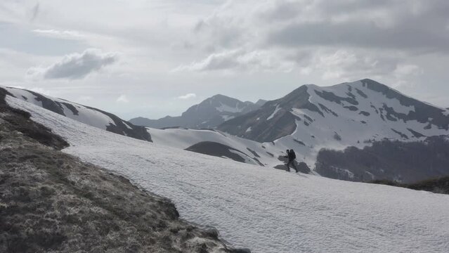 Beautiful adventurous trekking journey of lonely hiker on snowy mountains