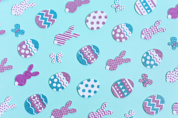 Happy Easter Pattern on blue. Decorative rabbits and eggs in rows. Paper cut glitter and sparkling colorful decorated Easter eggs, bunnies and butterflies with shadows.