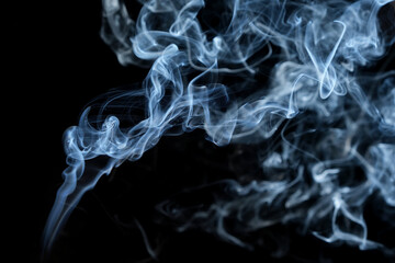 Twisted plumes of smoke, smoke movement on a black background. Abstract smoke lines