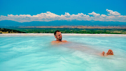 Portrait of man in water relaxing in swimming pool spa. Relax and spa concept.