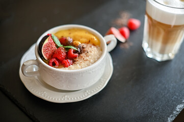 Breakfast oat porridge with berries and mango jam