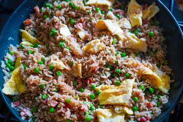 Close up of fried rice cooking in a frying pan 