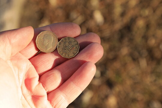 Old coin three pence in hand