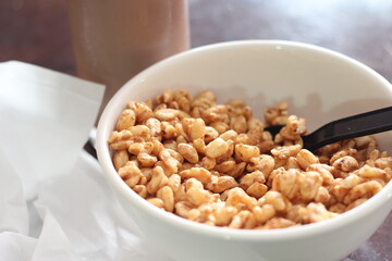 cereal in a white cup with chocolate milk in a ready-to-eat glass Served on a brown wooden table.