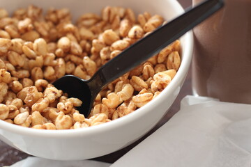 cereal in a white cup with chocolate milk in a ready-to-eat glass Served on a brown wooden table.