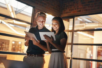 Putting their best productivity feet forward. Shot of two designers using their digital tablets while working nightshift.