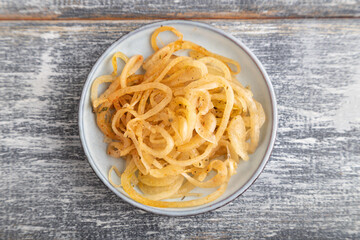 marinated onion on a gray wooden background. Top view, close up.
