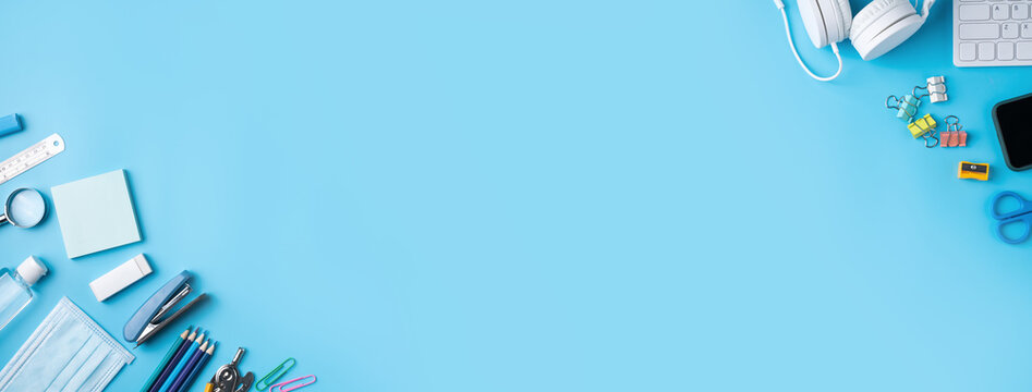 Online learning and back to school design concept. Top view of student table with headphone and stationery.