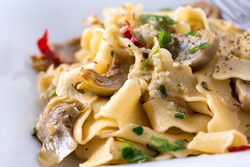 Piatto di deliziose tagliatelle piccanti con carciofi, Cucina Italiana 