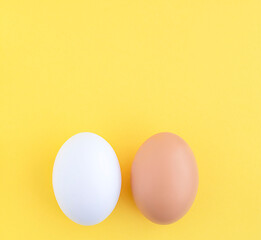 Food. Two Easter eggs white and brown on a yellow background, close-up. copy space.