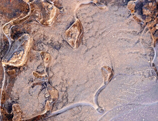 Abstract image of stones in frozen puddle. Cheshire, UK