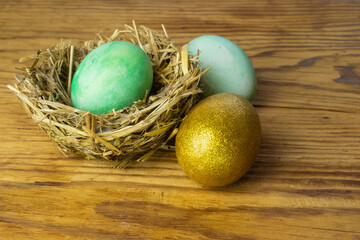 Image of a golden egg and colored eggs for Easter.