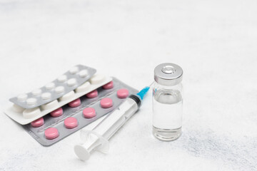 Medical syringe, medicine pills and glass vial on white background, medicine and treatment concept