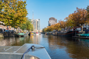 On a beautiful autumn day in the canal boat along the many old sailing boats on the Bierkade in The Hague
