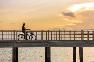 Obraz premium Middle aged woman with a bike on a bridge