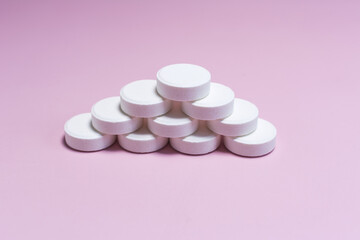 A pyramid of large white tablets on a light background.