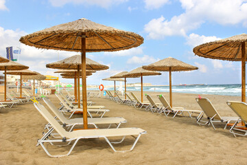 Beach with reed umbrellas on a clear sunny day