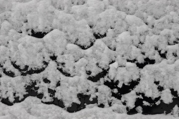 Beautiful winter background with snowy ground. Natural snow texture. Wind sculpted patterns on snow surface
