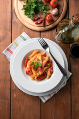 Piatto di deliziose penne all'arrabbiata, classica ricetta della Cucina Italiana 