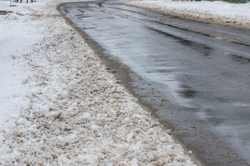 Winter road outside the city, cleared of snow in the countryside. Large snowdrifts on the side of the road