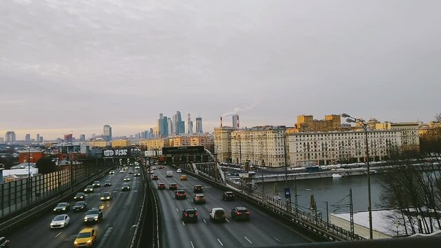 Heavy traffic of cars on the city highway. An urban landscape with office skyscrapers in the background. Andreevsky Bridge, Moscow, Russia.
