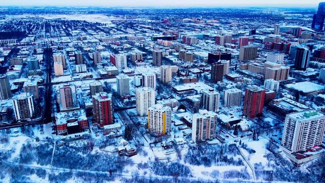 Downtown Edmonton Winter Westside Aerial hold at a semi birds eye view over the most luxurious residential properties with record snow covering the River Valley Park edge by the residential buildings