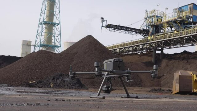 Steady slider shot of a large industrial drone on a sand plant factory