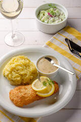 Paniertes und gebratenes Fischfilet mit Kartoffelpüree, Dillsauce und Zitrone