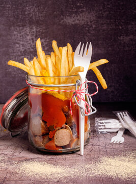 Currywurst mit Pommes Frites in einem Glas. Mantaplatte to go.