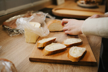 Mom cooks breakfast, spreads butter on a baguette