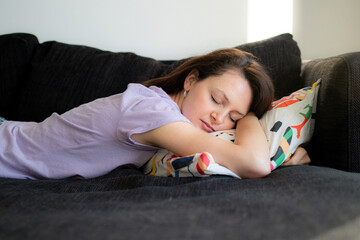 Daydreaming of a young woman during the day on a sofa