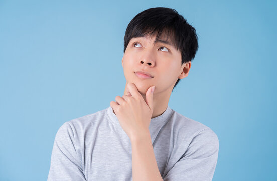 Young Asian man posing on blue background