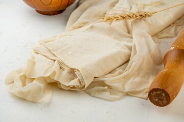 Thin filo dough on a white table.