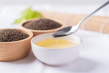 Perilla oil and seeds in bowl on white background, Healthy herbal seed ingredients in Asian food