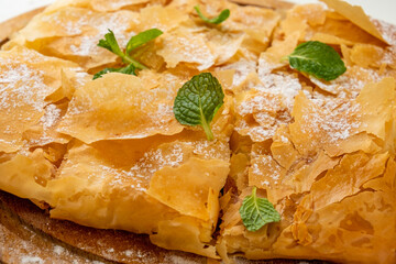 Sweet pastry Bougatsa made from thin filo dough. Greek cuisine. Close-up.